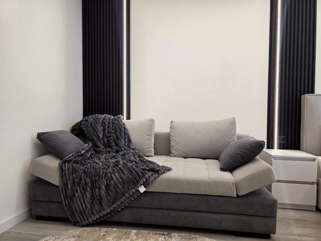 a living room with a couch with a blanket on it at Belvedere Apart, parking in Ivano-Frankivsk
