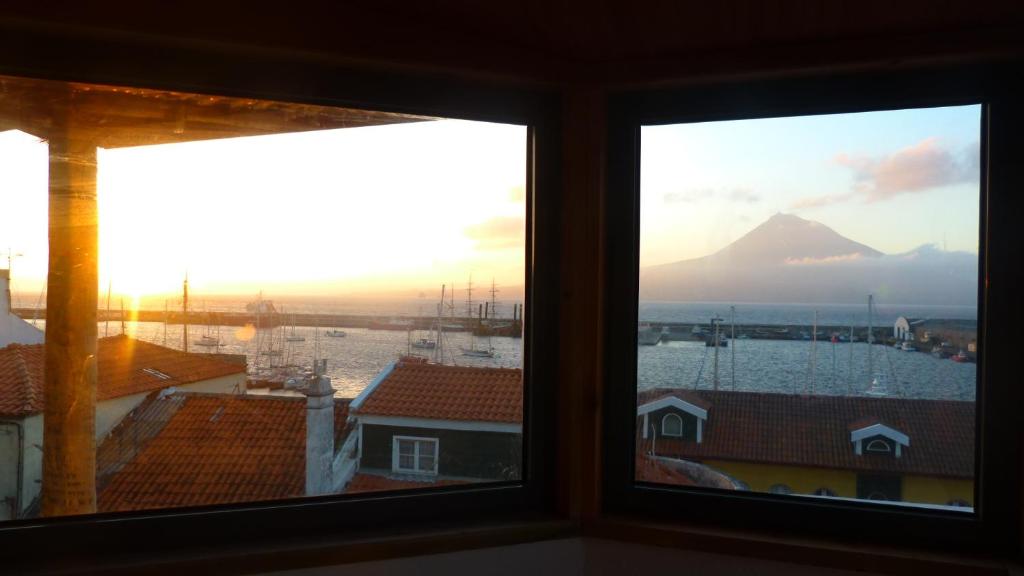 a view of a mountain from a room with two windows at Casa do Porto da Horta in Horta