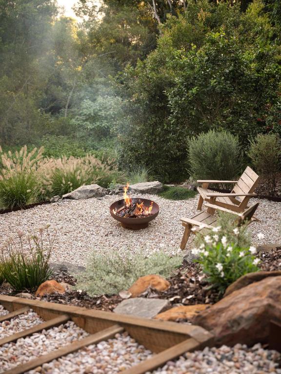 a fire pit and a bench in a garden at Oak Ridge Cottage in Maleny