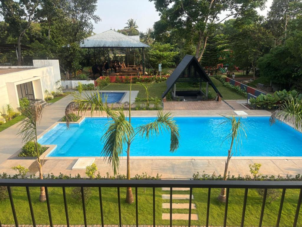 a view of a swimming pool from a balcony at Kaveri Pool Pavilion in Paravūr