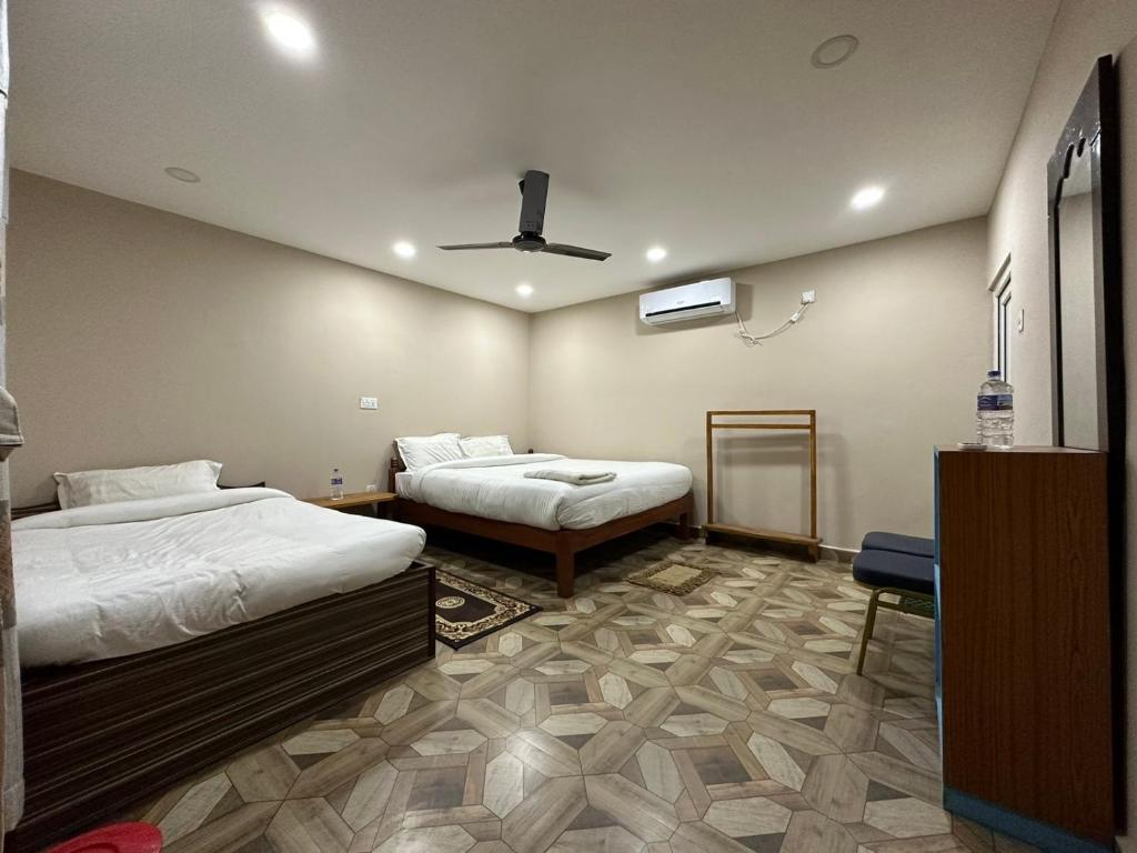 a bedroom with two beds and a ceiling fan at Narayani View Resort in Bharatpur