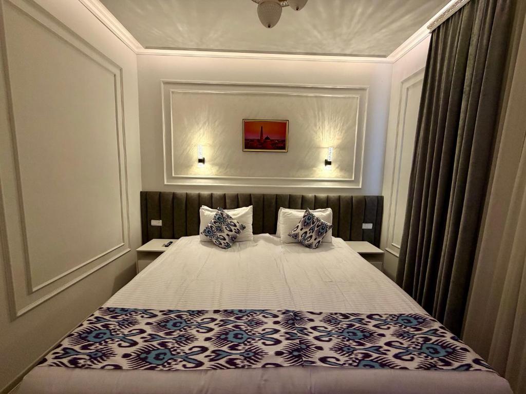 a bedroom with a bed with blue and white pillows at Isakhoja Boutique Hotel in Khiva