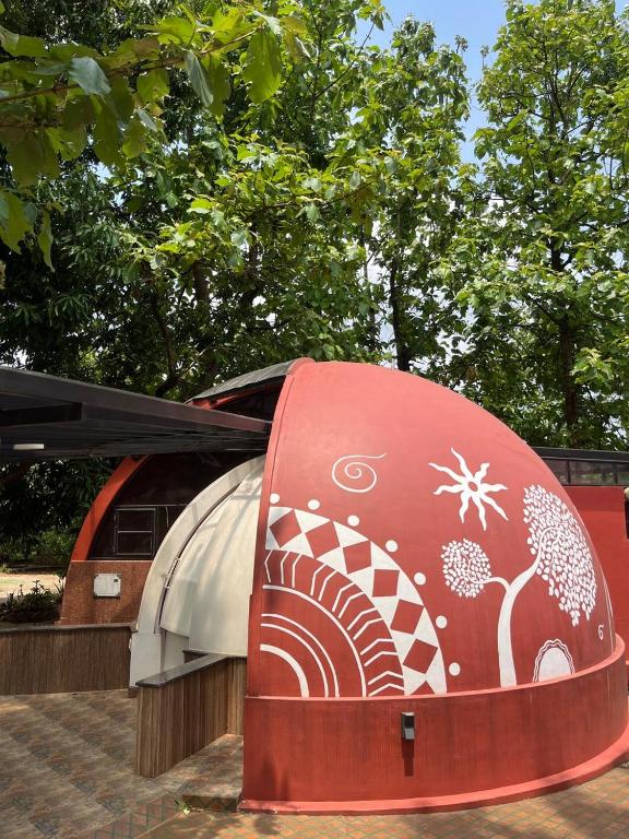 a red and white object with trees in the background at Infinity Farm Grove in Olavakod Junction