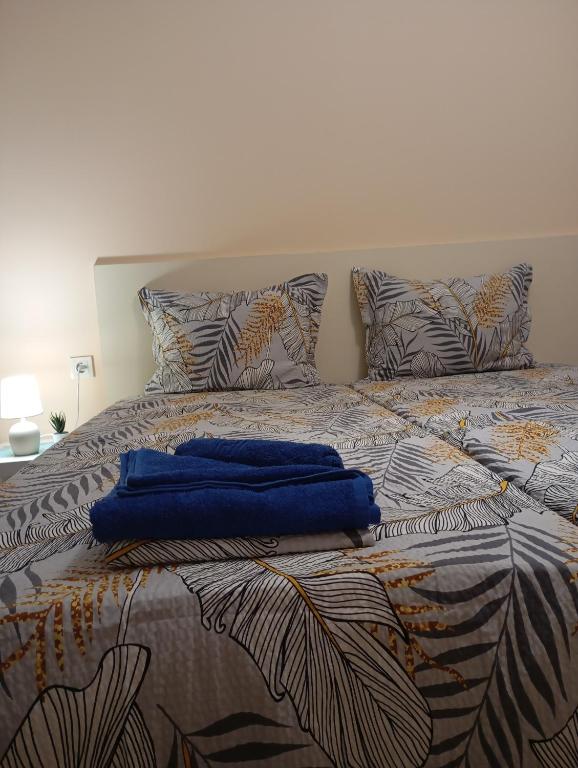 a bed with a blue towel on top of it at ADELA Apartment center city in Ruse