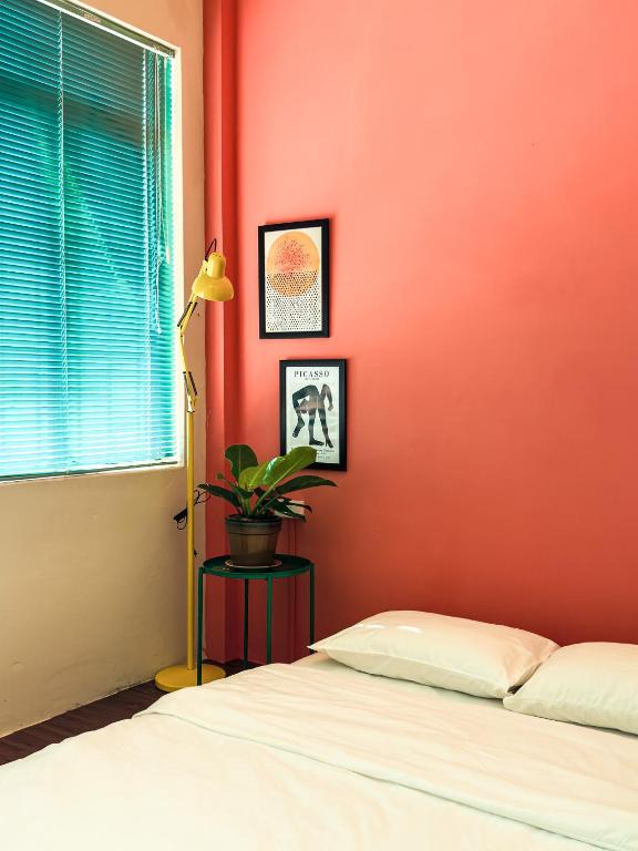 a bedroom with a bed and a red wall at XOM House - Nhà nguyên căn trung tâm Pleiku in Plei Brel (2)