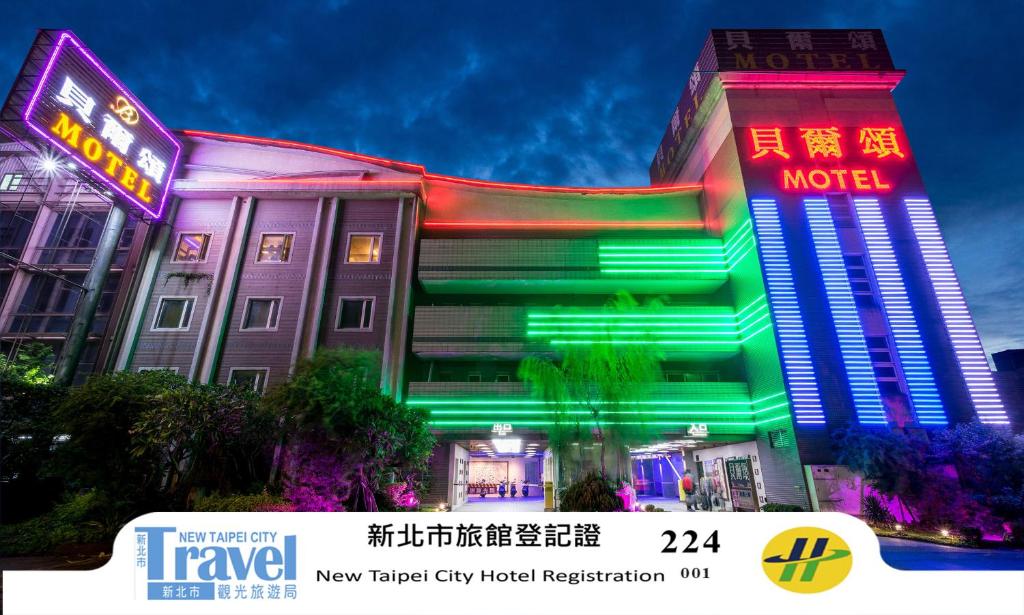 a hotel with a neon sign in front of it at Belle Song Motel in Shulin