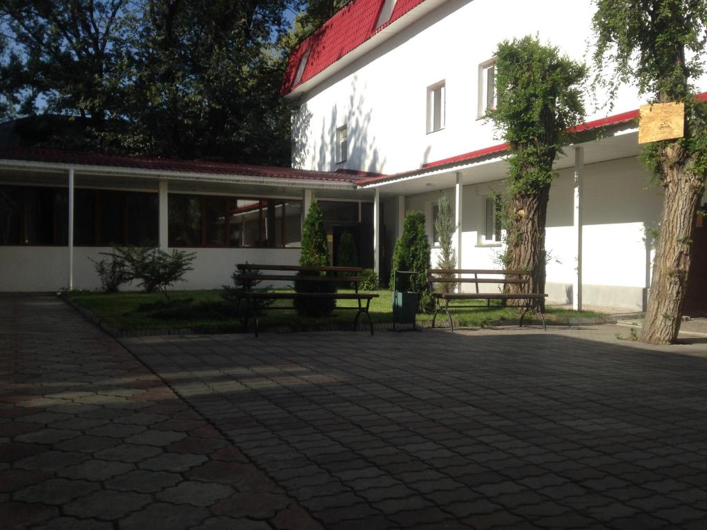 a white building with benches in front of it at Fiveseasons in Almaty