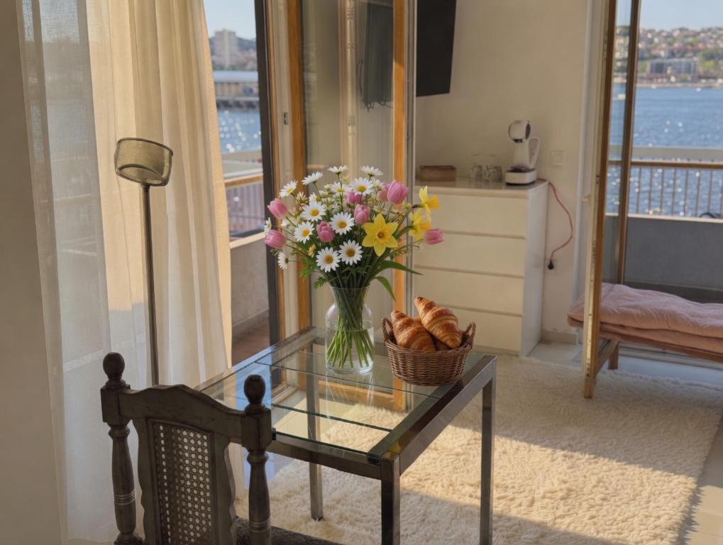 a vase of flowers on a glass table in a room at Basic Mansion Mandalina in Šibenik