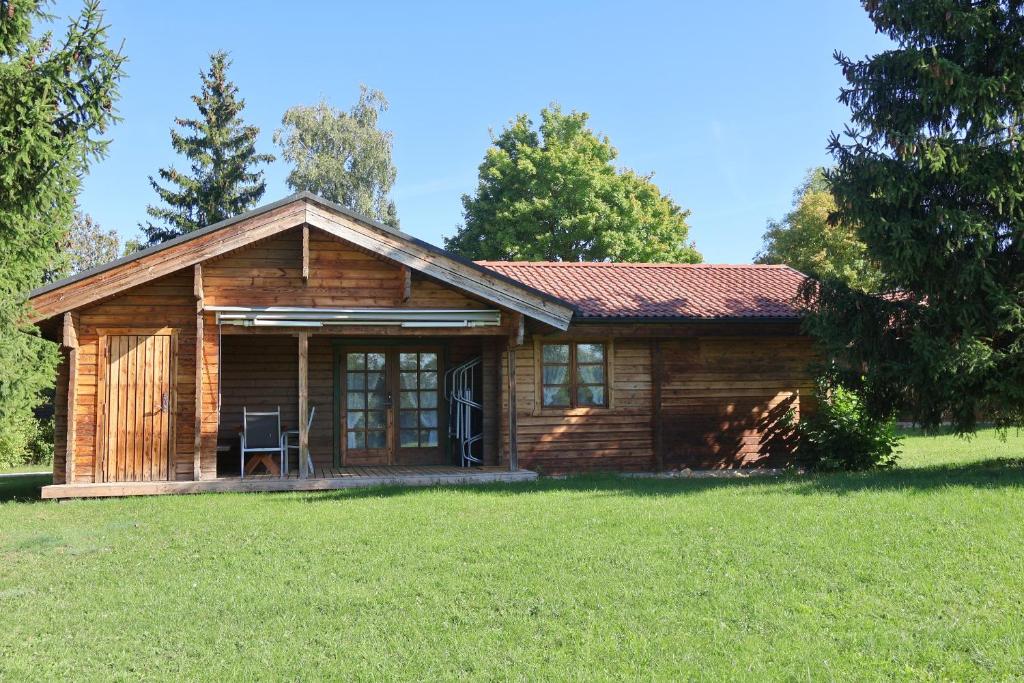 a log cabin in a field with a grass yard at Ferienhaus Neckar 46 in Hayingen
