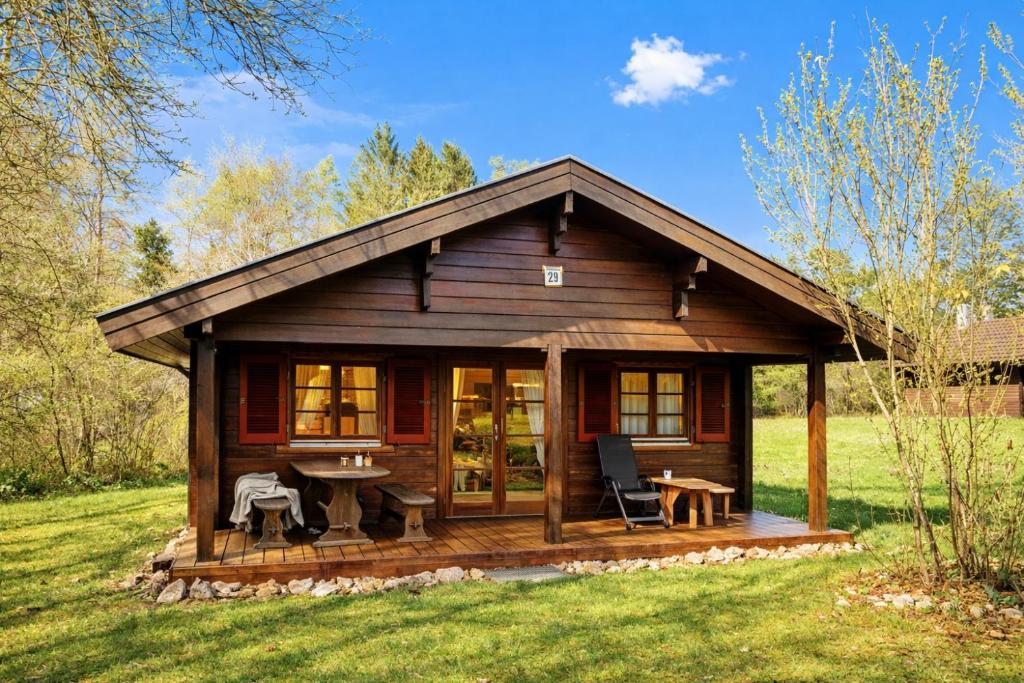 a log cabin with a table and chairs in a field at Ferienhaus Tauber 29 in Hayingen