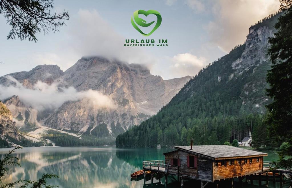 a cabin on a dock on a lake with mountains at App mit Klima, Pool, Garage für Auto, Bike, Skier, AktivCARD optional in Sankt Englmar