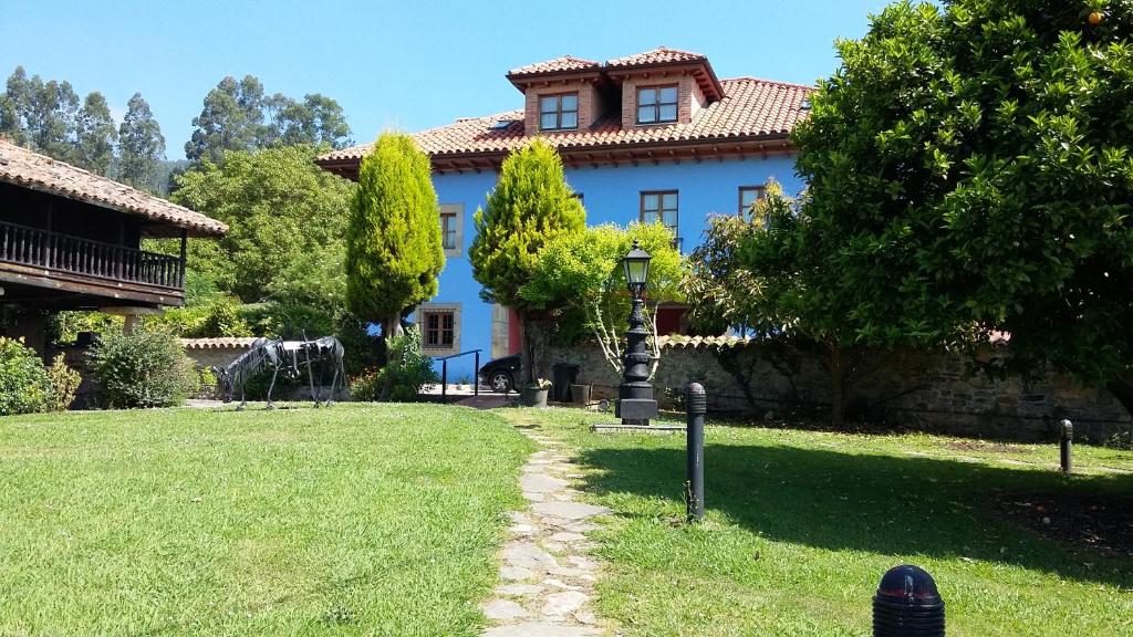 une maison bleue avec une aire de jeux dans la cour dans l'établissement Complejo turístico Quinta La Espadaña, à Bedriñana