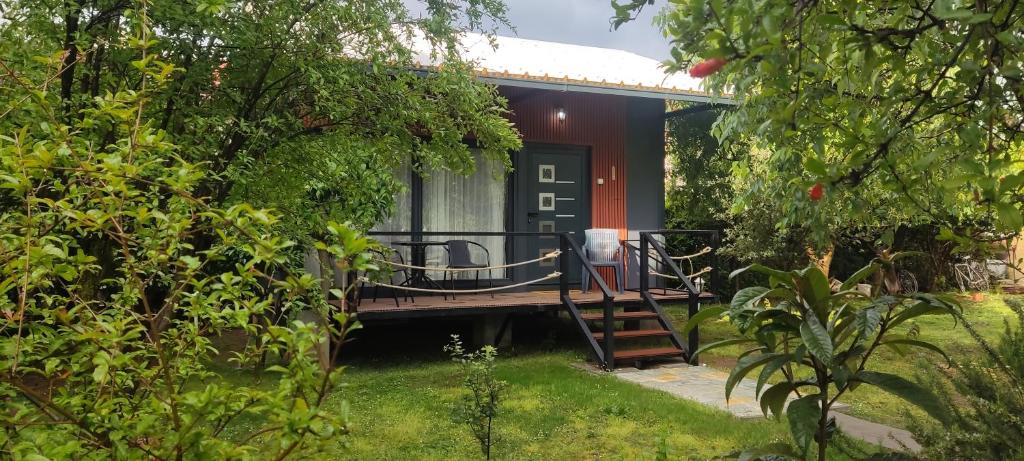 a small house with a deck in a garden at Iskra Tiny House in Podgorica