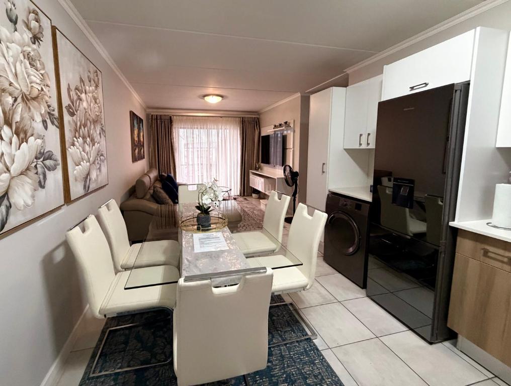 a kitchen and living room with a table and chairs at Charming Oasis in the East in Boksburg
