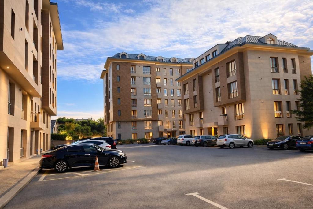 a parking lot with cars parked in front of buildings at Premium Airport Residence 2 in Baku