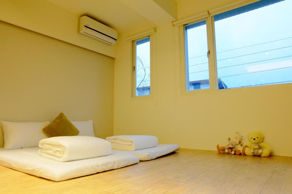 a bedroom with two beds in a room with windows at Buenos Garden Home Stay in Dayin