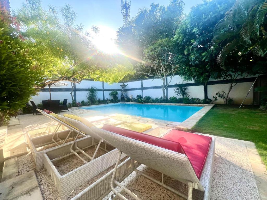 a swimming pool with a lounge chair next to a swimming pool at Peninsula Villa in Nusa Dua