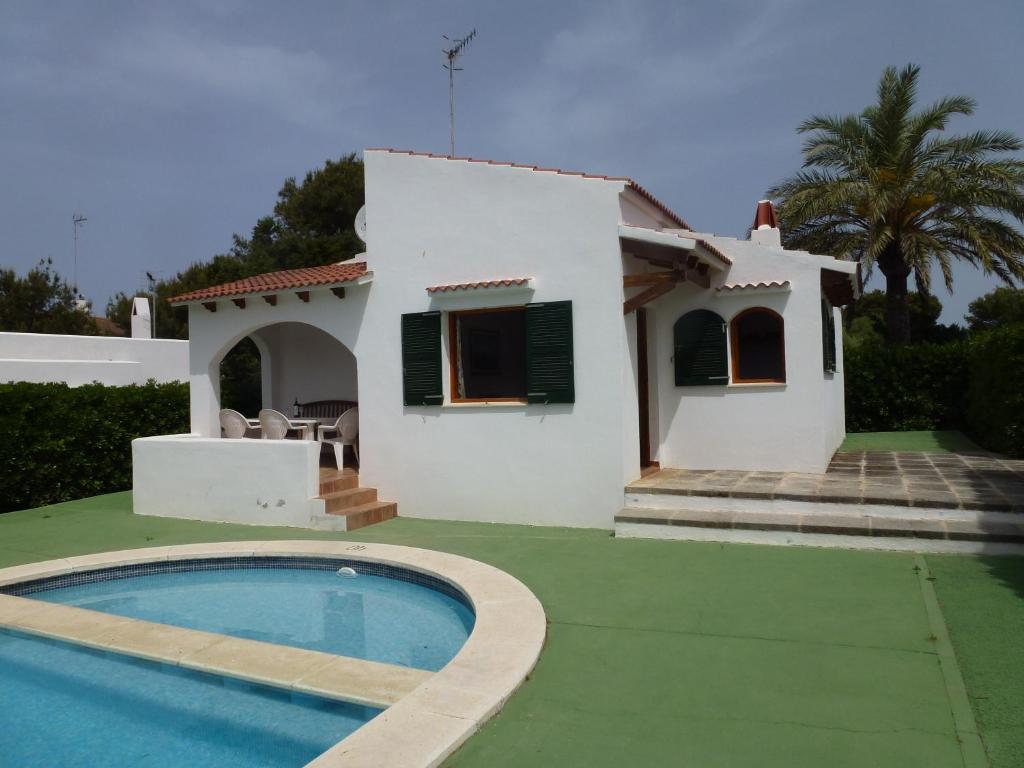 a villa with a swimming pool in front of a house at Villa Gaya in Cala Blanca