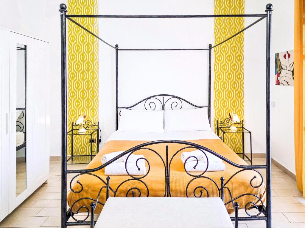 a bedroom with a black canopy bed with yellow wallpaper at Mamma Lucia in Sorrento