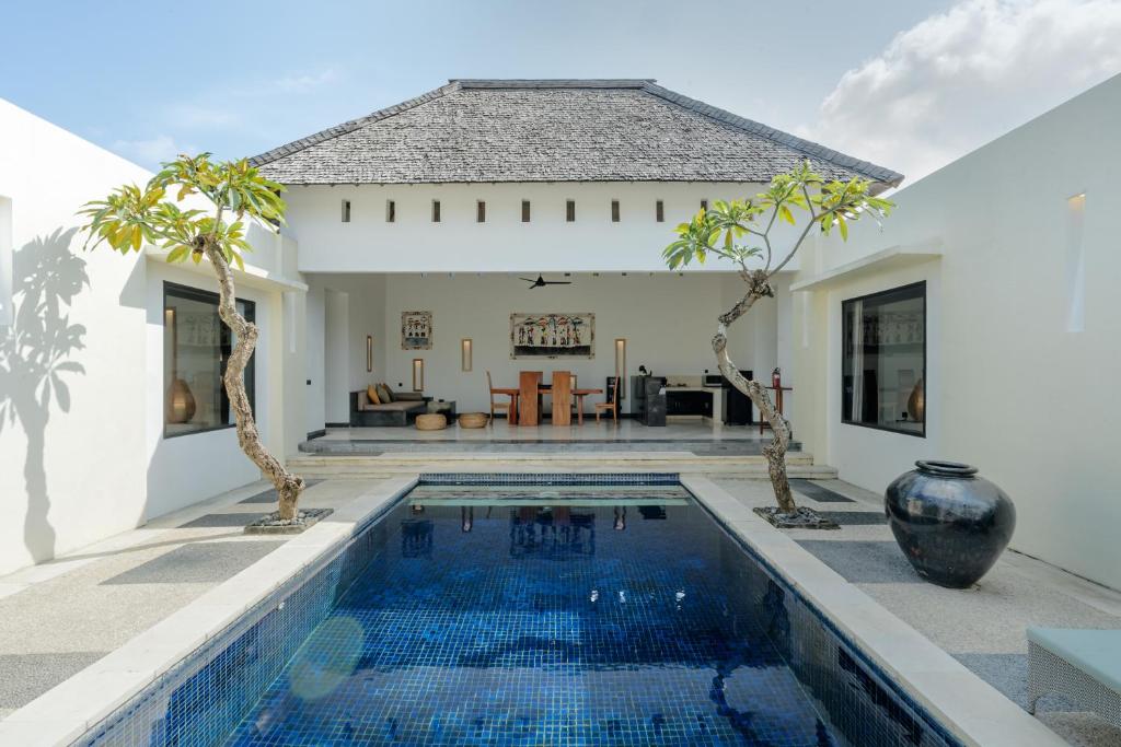 a villa with a swimming pool and a house at The Seminyak Suites Private Villas in Seminyak