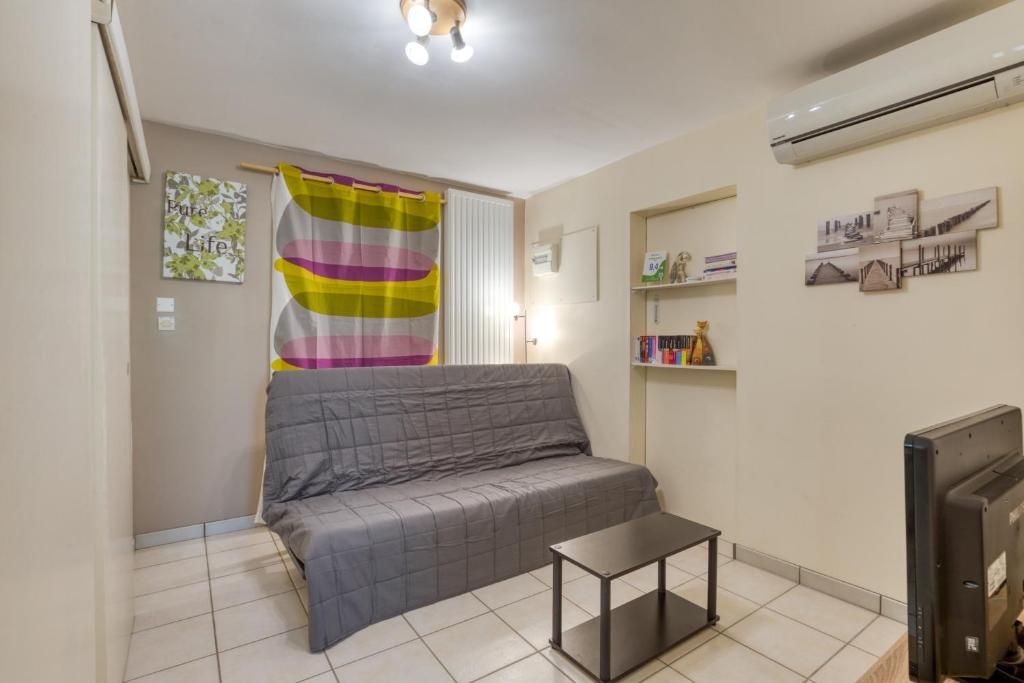 a living room with a bed and a tv at La Colline des Pins in Aniane