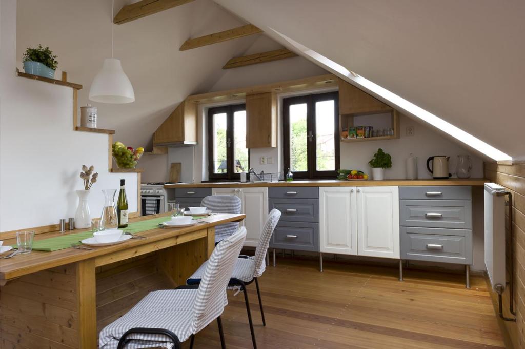 a kitchen with a wooden table and white chairs at Fair Haven - Dobrej přístav in Lomnice nad Popelkou