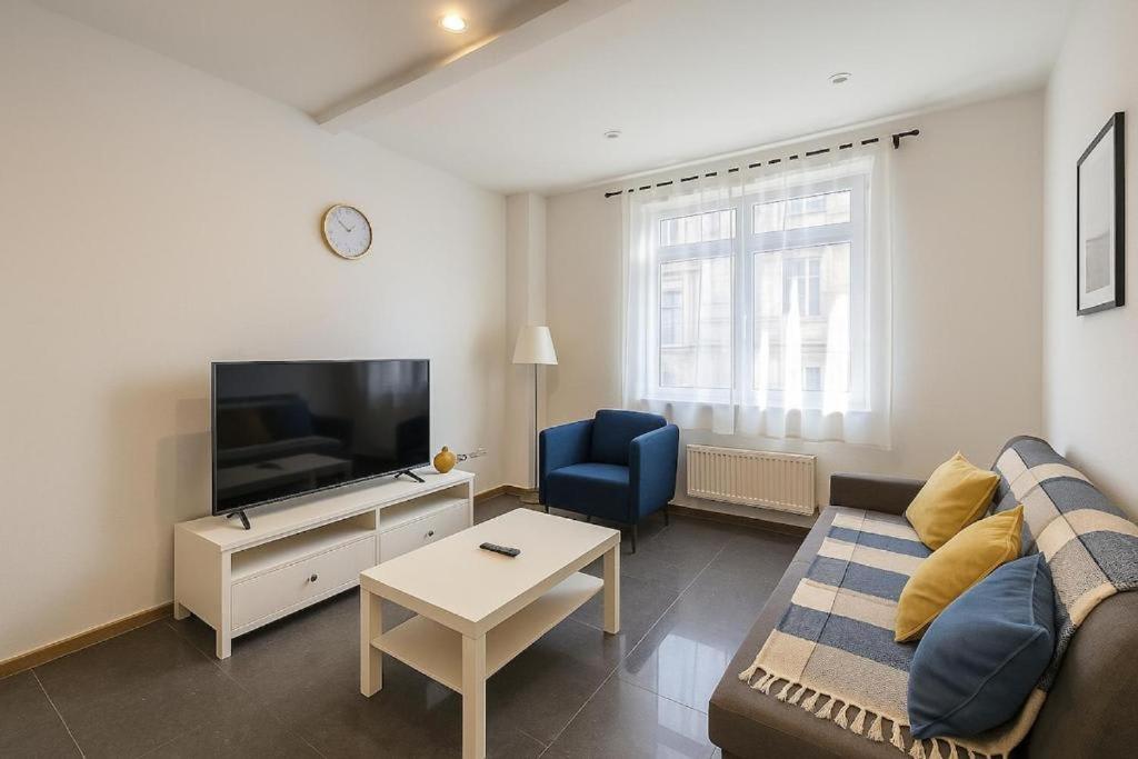 a living room with a couch and a tv at Midi station in Brussels