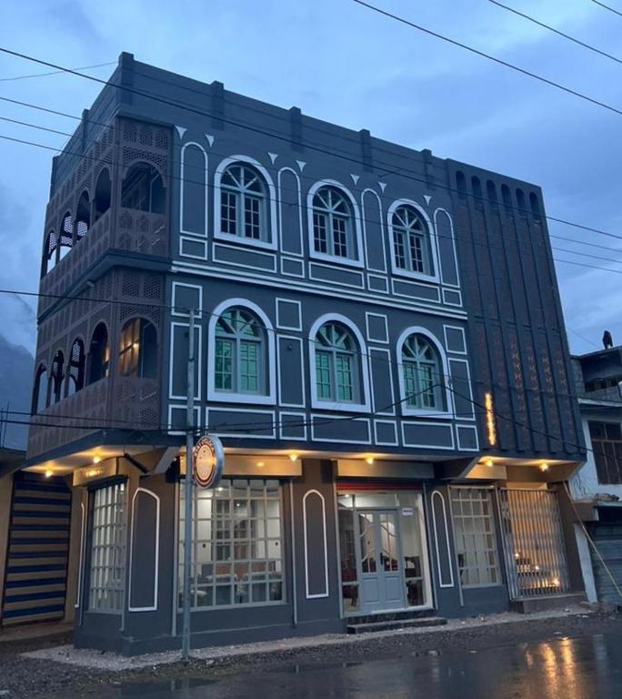 a blue and white building on the corner of a street at Stay O'clock Hotel Skardu in Skardu