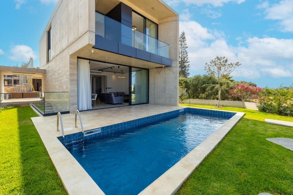 a house with a swimming pool in front of it at MITO Seaview by Serbellas in Kissonerga