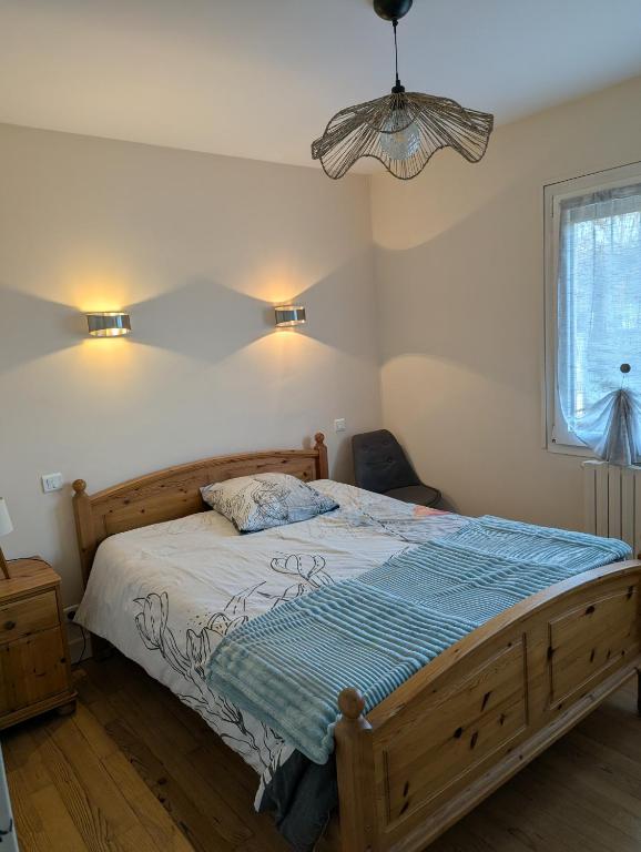 a bedroom with a wooden bed and a window at Havre de paix in La Celle-sous-Gouzon