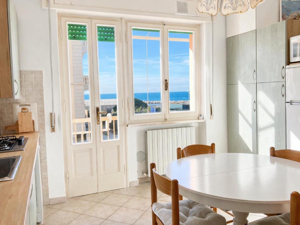 a kitchen with a table and a table and a window at Vista Mare nel Corso in San Vincenzo