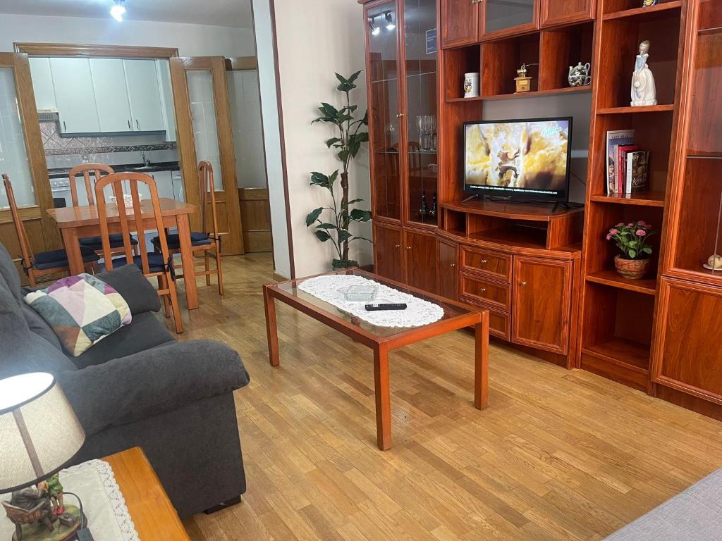 a living room with a couch and a tv at Amplio Loft con plaza de garaje in Cangas de Onís