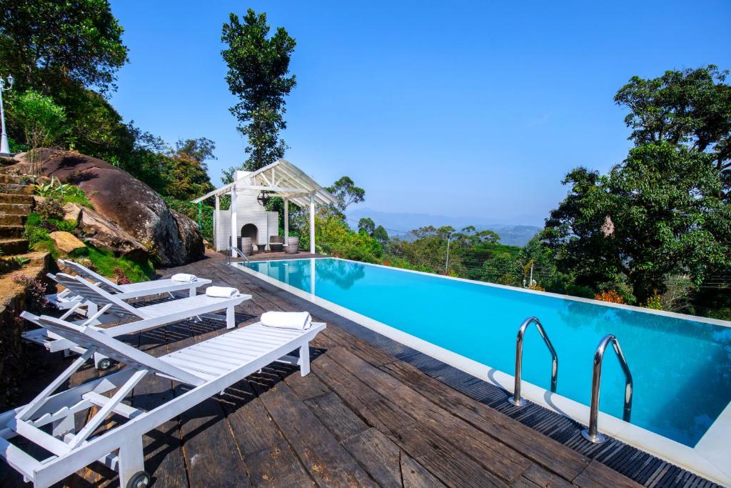 a pool at a resort with chairs and a gazebo at Andriyala in Haputale