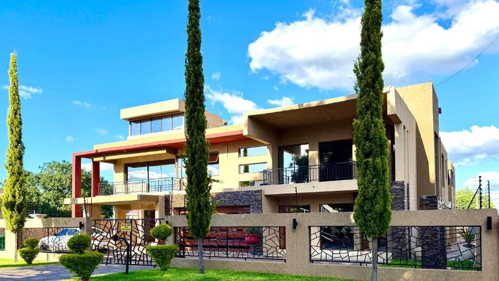 a building with trees in front of it at Escapade Lux Boutique Residence in Gaborone