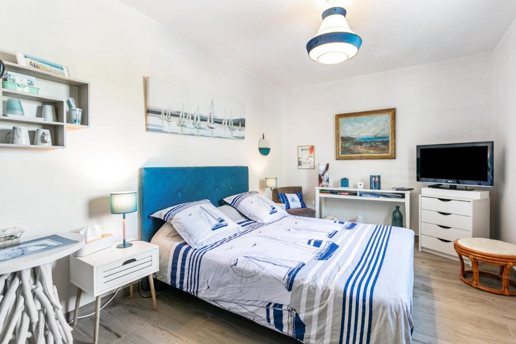a bedroom with a bed and a desk and a tv at Chambre d'hôtes Marine in Binic