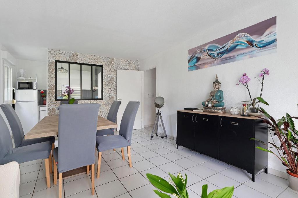a kitchen and dining room with a table and chairs at Le Cocon De Laurence in Pleurtuit