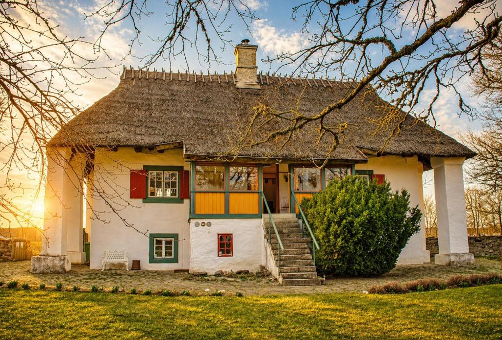 a large white house with a thatched roof at Tôlluste Villa in Tõlluste