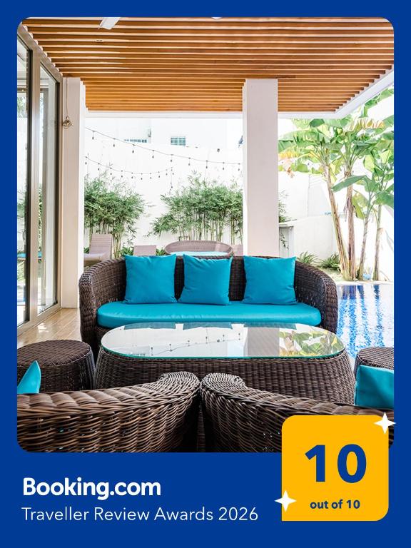 a patio with a blue couch and wicker furniture at Perfect Son Tra Beach Villa Da Nang with sea view in Danang