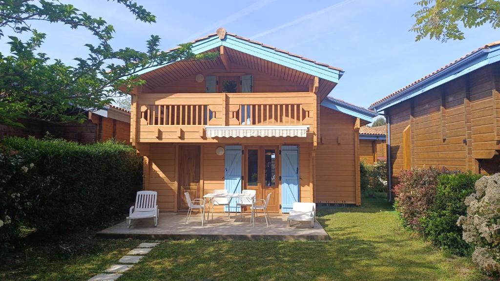 una casa con una mesa y sillas en el patio en Chalet à l'océan, en Bias