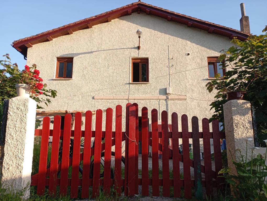a red fence in front of a house at Estación celorio in Celorio