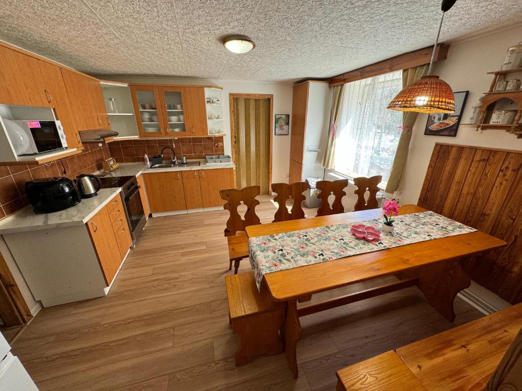 a kitchen with a wooden table and a dining room at Apartmány 107 in Olešnice v Orlických horách