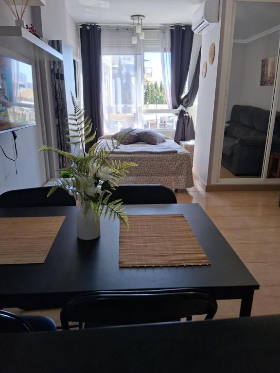 a living room with a table and a bed at Studio Benal Iris in Málaga