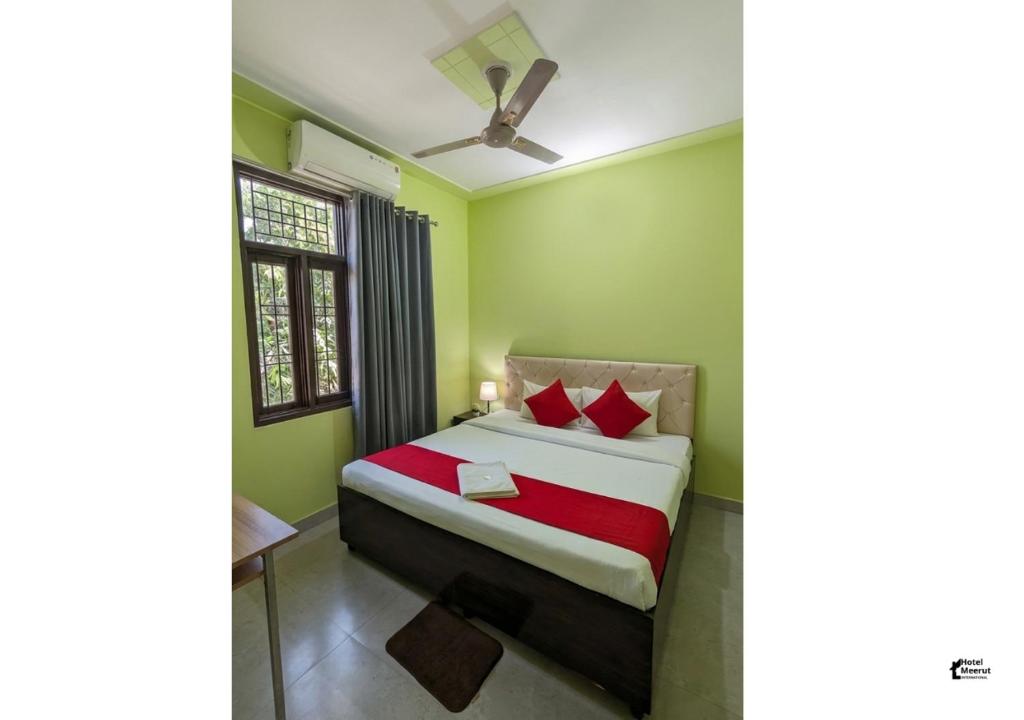 a bedroom with a bed with green walls and a ceiling at Hotel HMI International in Meerut