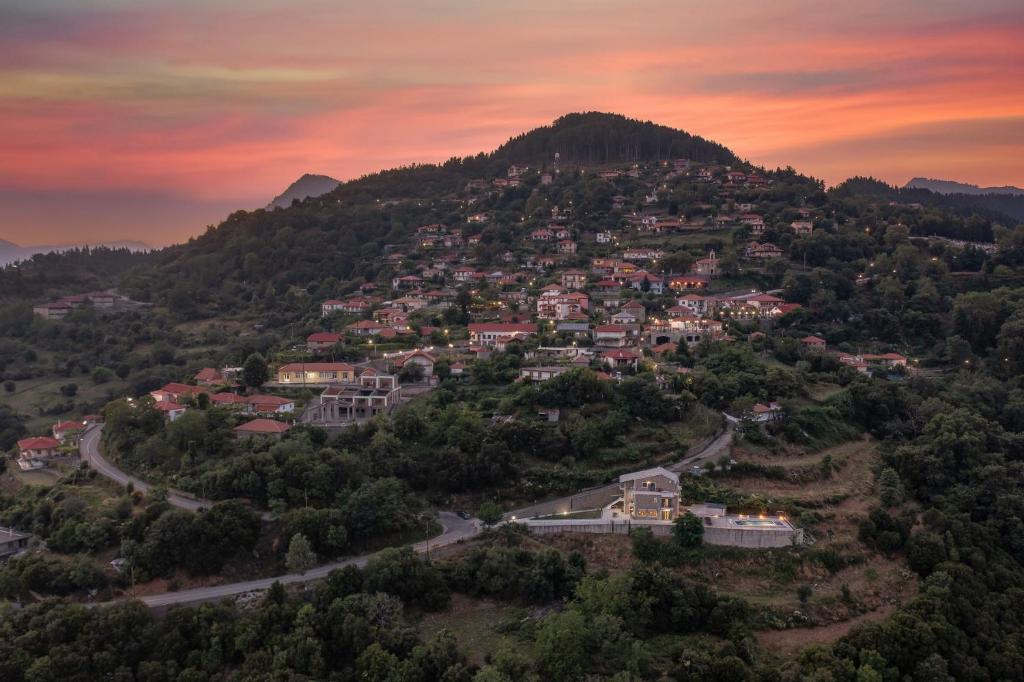 a town on top of a hill at sunset at Lithorama Granitsa mountain rooms in Granitsa