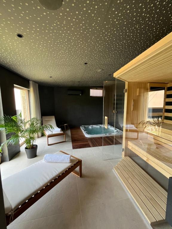 a room with a tub and a bed and a couch at Hiša Marija Private Spa Villa in Zgornje Škofije