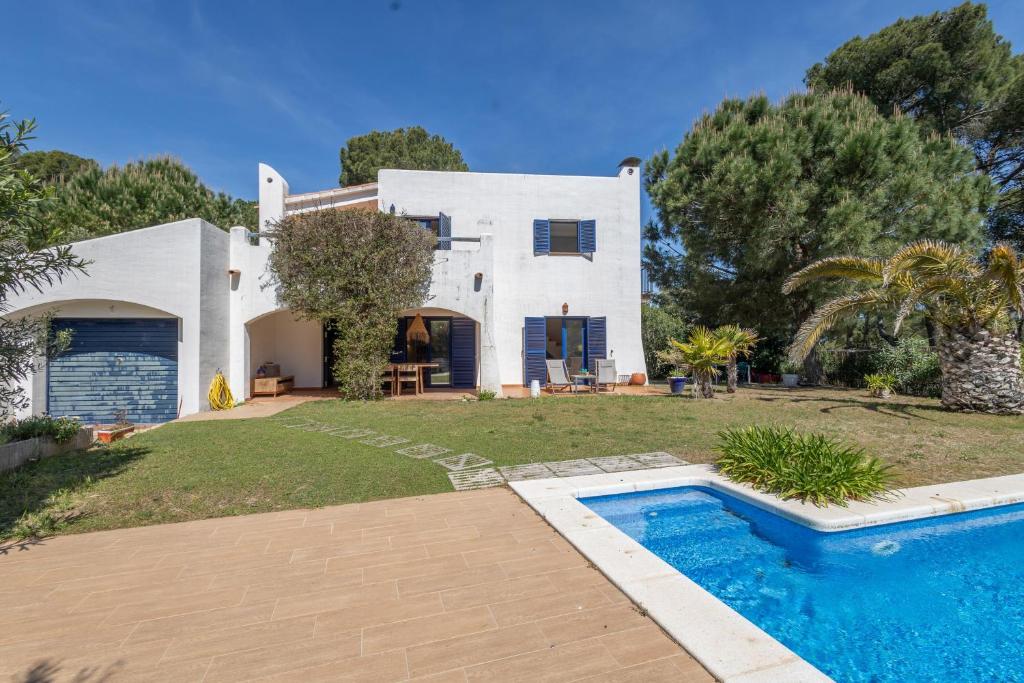 a villa with a swimming pool in front of a house at Bosc in Pals