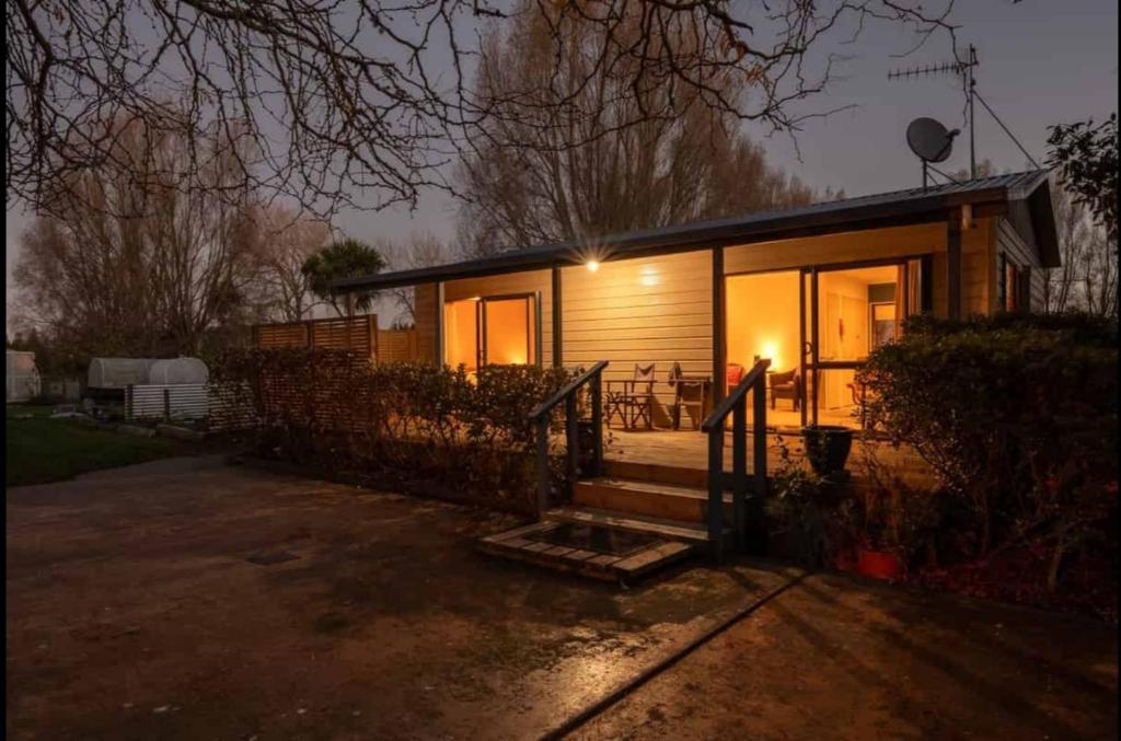 a small house with the lights on at night at Minffordd Cottage in Feilding