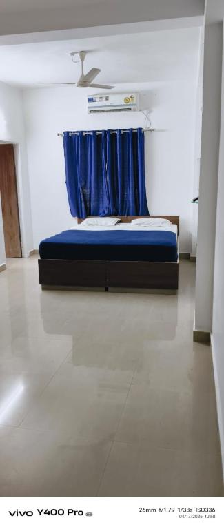 a bedroom with a blue bed with a blue curtain at hotel pappilon costal crown ac rooms in Mangalore
