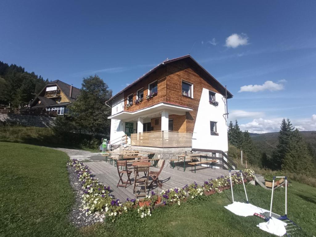 a house with a table and chairs in front of it at Domček Horskej Služby in Liptovská Sielnica