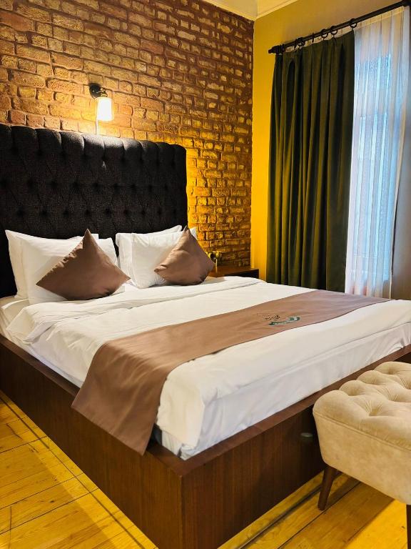 a large bed in a bedroom with a brick wall at Berfinn Hotel Beşiktaş in Istanbul